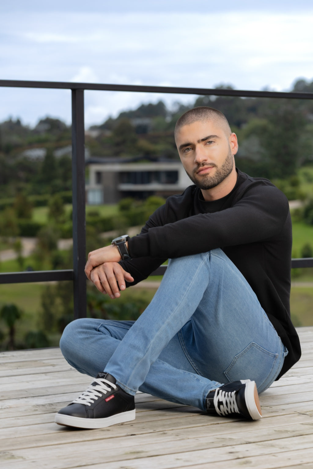 Tenis Casual en Napa de Perfil Bajo - modelo sentado en escalones usando tenis negro casual