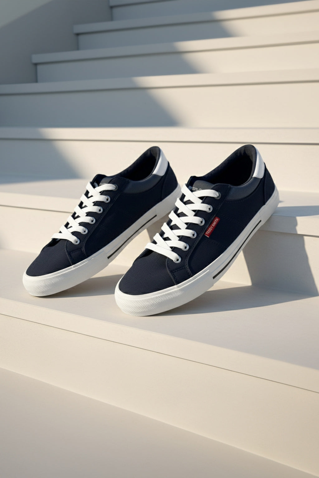 Tenis Casual en Lona con Apliques en Nobuck y Napa - vista de par de tenis negro y blanco sobre escalón